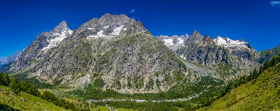 Panoramic view of Chamonix Valley showing forest, river, and steep mountain walls beneath the Mont Blanc massif in France.
