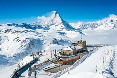 Gornergrat summit viewpoint with cogwheel train and visitors overlooking the Matterhorn and surrounding glaciers near Zermatt