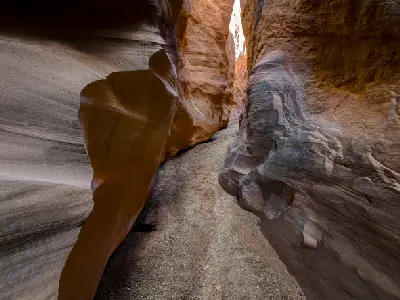 Smooth sculpted sandstone walls twist around the narrow sandy passage through Dry Fork Narrows near Peek-a-Boo and Spooky slot canyons.