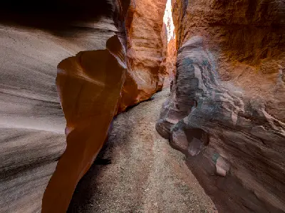 Smooth sculpted sandstone walls twist around the narrow sandy passage through Dry Fork Narrows near Peek-a-Boo and Spooky slot canyons.