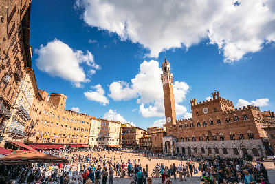 Crowds in Piazza del Campo with Torre del Mangia and Palazzo Pubblico in Siena, Tuscany, Italy.