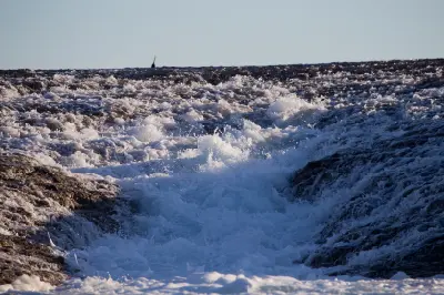 Rushing tidal water cascades across the exposed surface of Montgomery Reef as the tide falls.