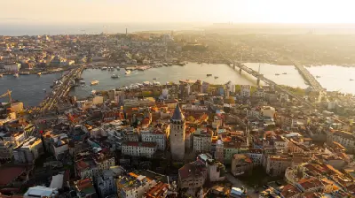 Aerial view of Galata Tower, Galata Bridge and the Golden Horn at golden hour in Istanbul.