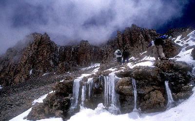 Climbers ascending the icy crater rim below Uhuru Peak on Mount Kilimanjaro, Tanzania.
