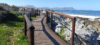 Wooden ocean walkway along the rocky coastline of Kleinmond in the Western Cape, South Africa