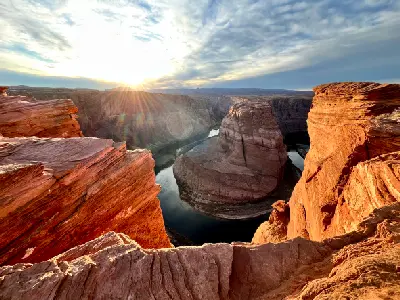 Horseshoe Bend sunset from cliff edge showing Colorado River meander and sandstone walls Page Arizona