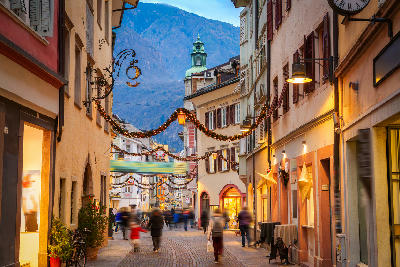 Night view of Bolzano, showing the illuminated historic centre set within the valleys of South Tyrol, Italy.