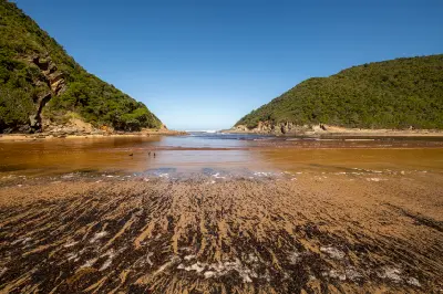 Salt River Mouth opening into the Indian Ocean between forested hills near Nature's Valley on South Africa's Garden Route.