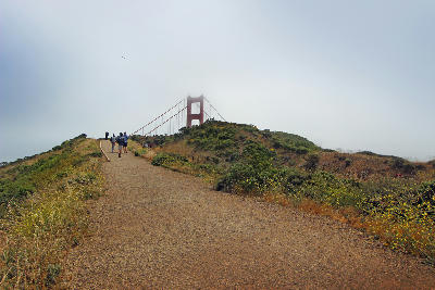 Visitors walking along the trail toward Battery Spencer with the Golden Gate Bridge ahead