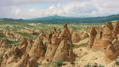 Panoramic view of fairy chimneys and sculpted volcanic rock formations in Devrent Valley, Cappadocia, Turkey.