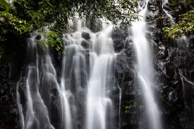 Close-up of white water cascading over dark, stepped rock formations at Ellinjaa Falls in the Atherton Tablelands, Queensland.