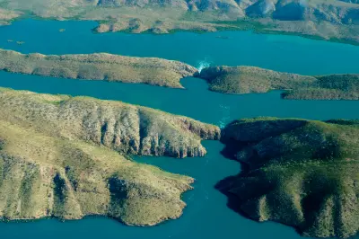 High aerial view of turquoise tidal waters passing through two narrow gaps in the rugged McLarty Range at Horizontal Falls.