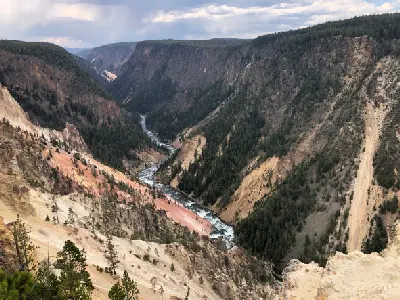 Deep canyon with the Yellowstone River flowing between colorful rock walls in Yellowstone National Park, Wyoming.