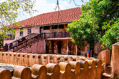 Historic prison building on Prison Island, Zanzibar, featuring coral stone walls, wooden balconies, and tropical trees.