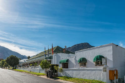 Cape Dutch guesthouses and village streetscape in Franschhoek Village with mountain backdrop in the Western Cape, South Africa.