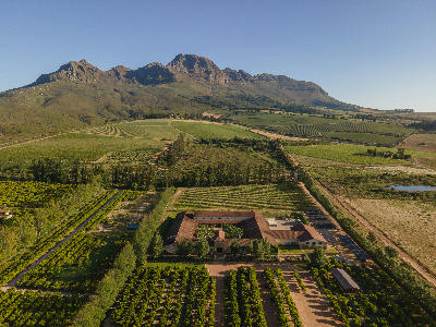 Drone view of Waterford Estate surrounded by vineyards and agricultural landscapes below the Helderberg Mountains in Stellenbosch, Western Cape, South Africa.