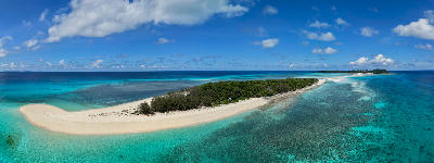 Panoramic drone view of the Nosy Iranja sandbar in Madagascar with white sand, turquoise lagoon water, coral reef textures, and tropical islands in the Indian Ocean.