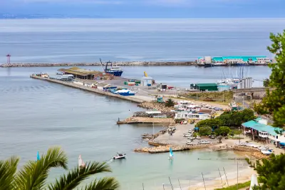 View across Mossel Bay Harbour showing fishing infrastructure, marina berths, breakwaters and waterfront facilities in the Western Cape, South Africa.