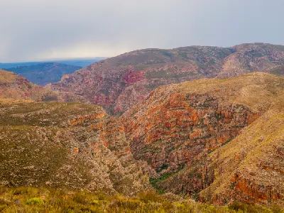 Canyon landscape of the Red Stone Hills near Oudtshoorn in the Little Karoo with layered red rock cliffs and rugged semi-arid terrain in South Africa