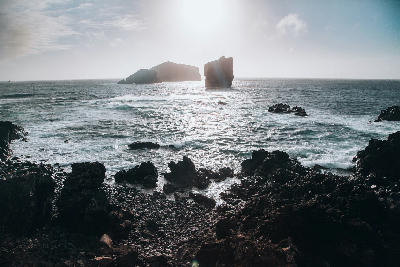 Waves breaking along the volcanic coastline near Mosteiros Beach with the Ilhéus dos Mosteiros sea stacks offshore on São Miguel Island, Azores.