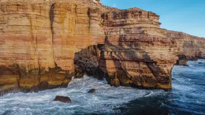 Waves surge beneath the layered sandstone arch of Natural Bridge on the Kalbarri coast.