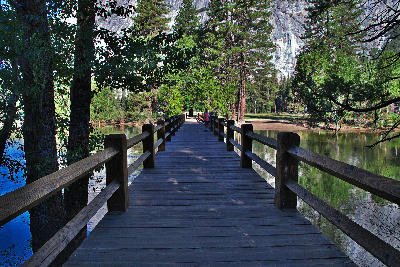 Sentinel Bridge over the Merced River with trees and granite valley walls in Yosemite National Park.