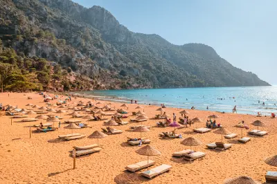 Sandy İztuzu Beach with forested mountains and turquoise sea near Dalyan, Turkey.