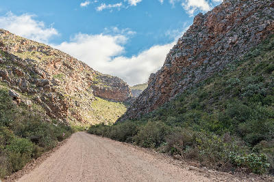 Gravel road passing through the sandstone gorge of Seweweekspoort in the Swartberg Mountains of South Africa's Klein Karoo.