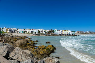 Club Mykonos resort in Langebaan with whitewashed Mediterranean-style buildings stretching along a sandy beach beside the Atlantic Ocean in the Western Cape.