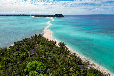 Drone view of Nosy Iranja in Madagascar showing the white sandbar, turquoise lagoon waters, palm-covered islands, and shallow Indian Ocean reef patterns.