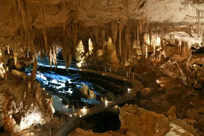 Stalactites and limestone formations surrounding an illuminated walkway inside Mammoth Cave near Margaret River, Western Australia.