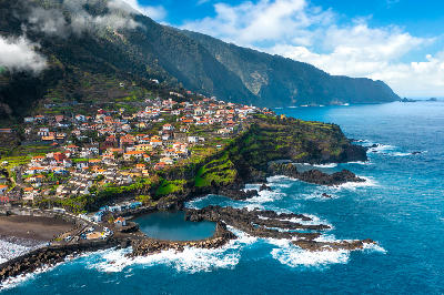 Aerial view of Seixal village and natural volcanic pools next to Praia do Seixal beach on Madeira Island, Portugal.