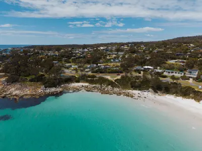 Aerial view of turquoise water, white beach and the coastal settlement of Binalong Bay, Tasmania.