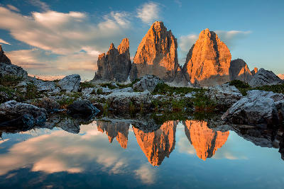 Tre Cime di Lavaredo (Drei Zinnen) reflected in a mountain lake at sunset in the Dolomites, South Tyrol, Italy.