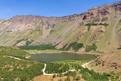 Small crater lake surrounded by steep volcanic slopes and green vegetation inside the Mount Nemrut caldera in eastern Turkey.