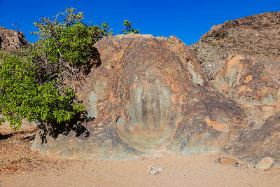 The Hand of God rock formation in Richtersveld National Park, with weathered granite surfaces, desert vegetation and rugged mountain slopes in the background.