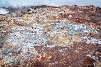 Steam rising from colourful geothermal ground with red and sulphur-stained soil at Gunnuhver, Reykjanes Peninsula, Iceland.
