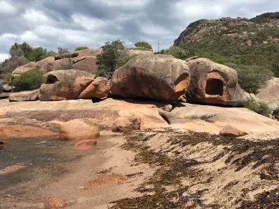 Weathered granite boulders and sculpted rock cavities along the shoreline at Sleepy Bay.