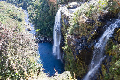 View from the top of Lisbon Falls showing water dropping into a deep plunge pool and forested gorge along the Panorama Route in Mpumalanga.