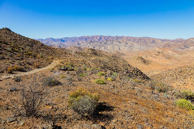 Mountain road descending through the rugged valleys and arid mountain landscapes of Helskloof Pass in the Richtersveld region of South Africa.