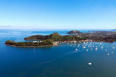 Drone view of Nosy Be in Madagascar with tropical bays, anchored boats, volcanic hills, and Indian Ocean coastline.