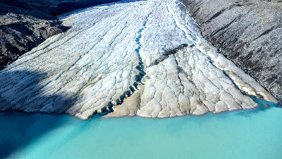 Melting glacier edge flowing into turquoise meltwater lake at the Columbia Icefield in Jasper National Park, Alberta, Canada