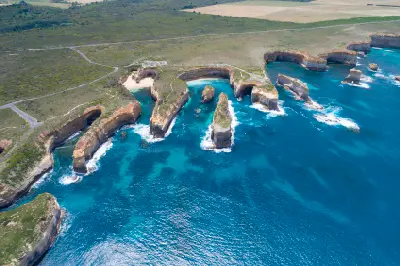 Aerial view of Loch Ard Gorge, coastal cliffs and limestone sea stacks on Victoria’s Great Ocean Road.