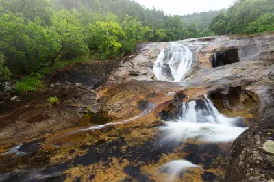 Water flowing over smooth granite terraces at Debengeni Falls in the forests of Magoebaskloof, Limpopo, South Africa.