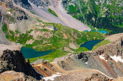 Aerial view of Blue Lakes Basin below Mount Sneffels, showing multiple turquoise alpine lakes and rocky ridgelines in the San Juan Mountains, Colorado.