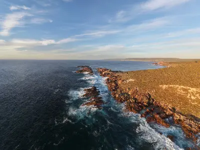 Aerial view of Canal Rocks showing granite ridges, narrow ocean channels and waves along the rugged Margaret River coast of Western Australia.