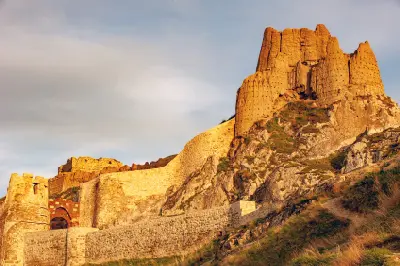 Stone defensive walls and weathered ruins of Van Castle rising across a rugged rocky ridge in eastern Turkey.