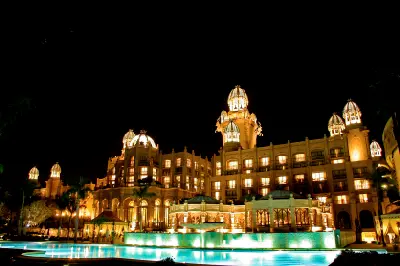 The Palace of the Lost City illuminated at night with reflecting pools and ornate towers at Sun City Resort, North West Province.