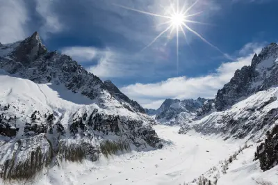 Wide view of the Mer de Glace glacier stretching through a snow-covered alpine valley in Chamonix, France.