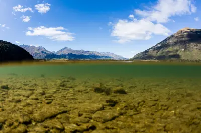 Clear shallow water and mountain reflections at Diamond Lake near Glenorchy, Otago, South Island, New Zealand.